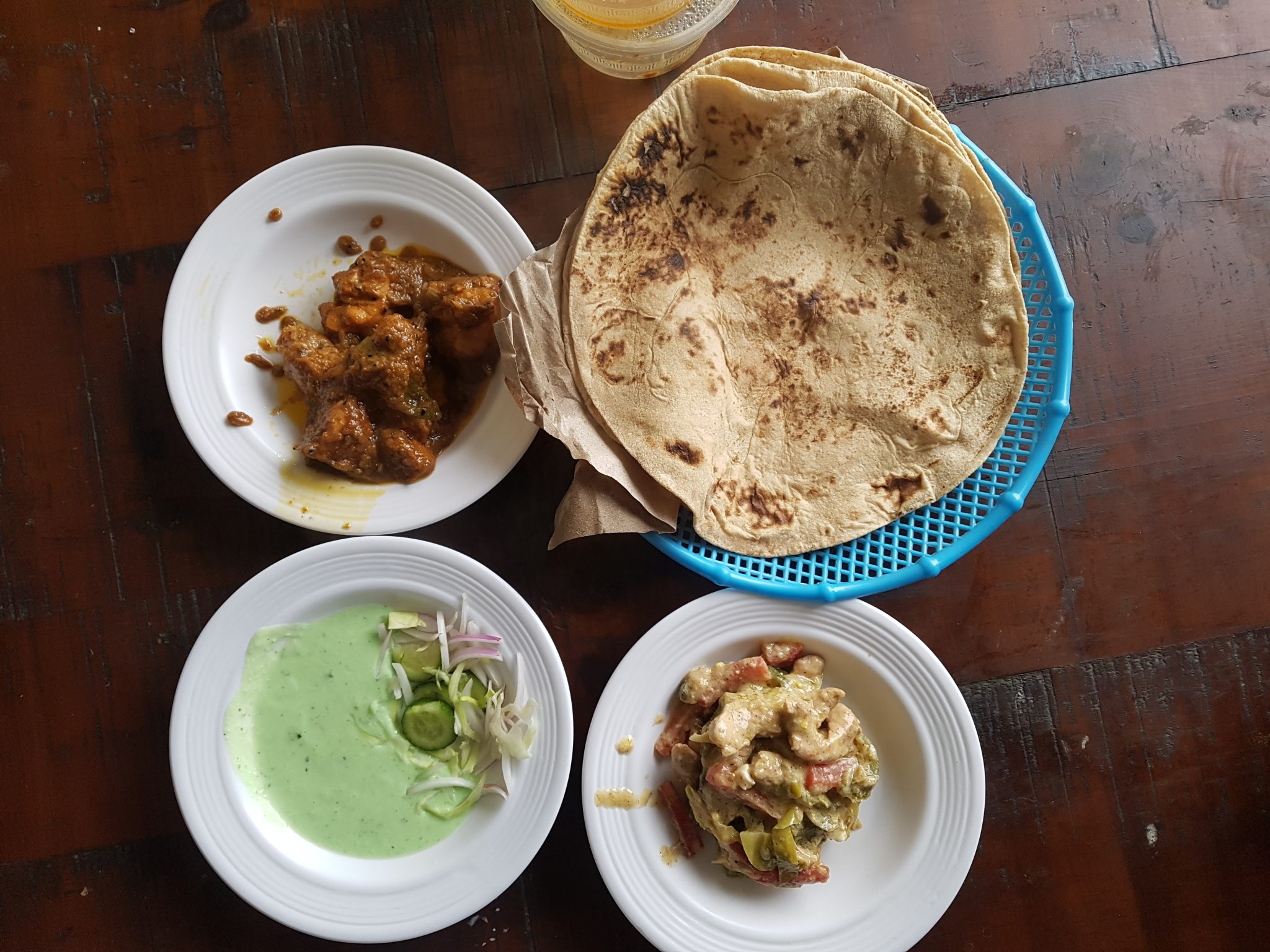 A dining table set with three distinct plates of food, showcasing a variety of dishes for a shared m